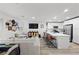 Open-concept living space with a modern kitchen, comfortable seating, and natural light from large windows at 6144 Rathbone St, Las Vegas, NV 89166
