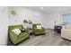Cozy living room with two olive colored armchairs and a view of the front door at 6144 Rathbone St, Las Vegas, NV 89166