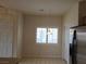 Open kitchen featuring stainless steel refrigerator, with view to a window and dining area and white door at 6461 Za Zu Pitts Ave # 102, Las Vegas, NV 89122