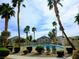 Community pool with lush landscaping, palm trees, and lounge chairs at 6461 Za Zu Pitts Ave # 102, Las Vegas, NV 89122