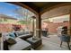 Covered backyard patio area with a comfortable seating area and a grill at 6470 Little Harbor Ct, Las Vegas, NV 89141