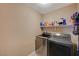 Modern laundry room with sleek, front-loading washer and dryer at 6470 Little Harbor Ct, Las Vegas, NV 89141