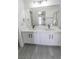 Bright bathroom features a double sink vanity with quartz countertops and tiled shower at 6586 Mount Roy Ln, Las Vegas, NV 89156