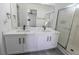 Bright bathroom features a double sink vanity with quartz countertops and tiled shower at 6586 Mount Roy Ln, Las Vegas, NV 89156