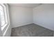 Cozy bedroom with neutral carpet, white walls, and a bright window at 6586 Mount Roy Ln, Las Vegas, NV 89156