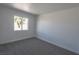 Bedroom featuring neutral paint, modern gray carpeting, and a large window at 6586 Mount Roy Ln, Las Vegas, NV 89156