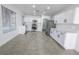 Bright kitchen with stainless steel appliances, white cabinetry, and tile flooring at 6586 Mount Roy Ln, Las Vegas, NV 89156