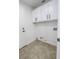 Clean laundry room with tile floors, white cabinets and utility sink hookups at 6586 Mount Roy Ln, Las Vegas, NV 89156