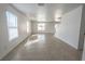 Spacious living room with tile floors, large windows, and stairs to second level at 6586 Mount Roy Ln, Las Vegas, NV 89156