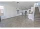 Spacious living area with stairs, white walls, and tile floors at 6586 Mount Roy Ln, Las Vegas, NV 89156