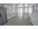 Bright living area with tile flooring, stainless steel refrigerator, and access to outdoor patio at 6586 Mount Roy Ln, Las Vegas, NV 89156