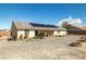 View of the home's backyard with a patio, solar panels, and gravel landscaping at 6751 Stubblefield Dr, Pahrump, NV 89061