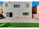 Exterior of home with stone patio, artificial turf, and exterior windows at 6773 Goose Watch Ct, Las Vegas, NV 89139