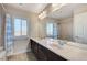 Bathroom with double sinks, large mirror, shower, and blue-striped shower curtain at 6773 Goose Watch Ct, Las Vegas, NV 89139