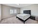 Bedroom with carpet, large window, queen-sized bed with black headboard, and nightstand at 6773 Goose Watch Ct, Las Vegas, NV 89139