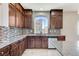 Close-up of a well-appointed kitchen showcasing granite countertops, dark wood cabinets, and stainless steel appliances at 6773 Goose Watch Ct, Las Vegas, NV 89139