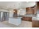 Well-lit kitchen boasts granite countertops, tile flooring, stainless steel refrigerator, and a functional center island at 6773 Goose Watch Ct, Las Vegas, NV 89139