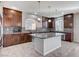 Gourmet kitchen featuring dark wood cabinetry, a center island, stainless appliances, and tile backsplash at 6773 Goose Watch Ct, Las Vegas, NV 89139