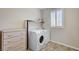 Well-lit laundry room includes washer, dryer, storage shelf and drawer at 6773 Goose Watch Ct, Las Vegas, NV 89139