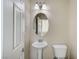 Cozy half bathroom featuring pedestal sink, elongated toilet, and decorative lighting at 6773 Goose Watch Ct, Las Vegas, NV 89139
