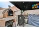 Outdoor kitchen area with a pizza oven and barbecue, perfect for hosting summer gatherings at 6929 Benson Ferry St, Las Vegas, NV 89149