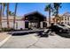 Clubhouse in a neighborhood with palm trees and a parking lot on a sunny day at 700 Carnegie St # 3214, Henderson, NV 89052