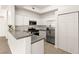 Modern kitchen with stainless steel appliances, white cabinets, and gray countertops at 700 Carnegie St # 3214, Henderson, NV 89052