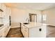 Bright, modern kitchen with an island, white cabinetry, and wood-look flooring at 728 Omaggio Pl, Henderson, NV 89011