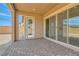 Spacious covered patio with brick flooring, providing access to the house through glass doors at 728 Omaggio Pl, Henderson, NV 89011