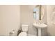 Clean powder room with pedestal sink and toilet featuring neutral paint and fixtures at 728 Omaggio Pl, Henderson, NV 89011