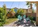 Backyard with patio and seating area, bordered by mature landscaping and trees at 8224 Opal Falls St, North Las Vegas, NV 89085