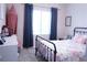 Charming bedroom with a floral-patterned bedspread, large window with dark curtains, and dollhouse decor at 8224 Opal Falls St, North Las Vegas, NV 89085