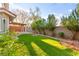 Spacious backyard features lush artificial turf, a covered patio, and mature landscaping for outdoor enjoyment at 8528 Sierra Cima Ln, Las Vegas, NV 89128