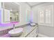 Bathroom featuring granite counters, dual sinks, decorative mirrors, and shutters on window at 8528 Sierra Cima Ln, Las Vegas, NV 89128
