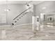 Bright and open living area with tile flooring, high ceilings, and a staircase to the upper level at 8528 Sierra Cima Ln, Las Vegas, NV 89128