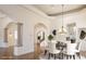 Elegant dining room featuring decorative chandelier, tray ceiling, arched entryway, and view to the fireplace at 9904 Moonridge Ct, Las Vegas, NV 89134