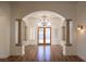 Elegant foyer features wood floors, chandelier, arched entryway, columns, and view to the double door entry at 9904 Moonridge Ct, Las Vegas, NV 89134