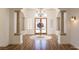 Elegant foyer features wood floors, chandelier, arched entryway, columns, and view to the double door entry at 9904 Moonridge Ct, Las Vegas, NV 89134