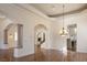 Elegant living room featuring decorative chandelier, tray ceiling, arched entryway, and view to the fireplace at 9904 Moonridge Ct, Las Vegas, NV 89134