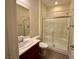 Bright bathroom with a vanity sink and a glass-enclosed shower-tub combination at 10145 White Mulberry Dr, Las Vegas, NV 89148