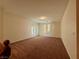 Large living room area with neutral tones, carpet flooring, and a sliding glass door at 10145 White Mulberry Dr, Las Vegas, NV 89148
