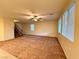 Open living room featuring plush carpeting, a ceiling fan, and large windows for natural light at 10145 White Mulberry Dr, Las Vegas, NV 89148