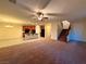 Expansive living area with a ceiling fan, open staircase, and a view into the adjacent kitchen at 10145 White Mulberry Dr, Las Vegas, NV 89148