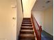Carpeted staircase with a wood railing, connecting different levels of the home seamlessly at 10145 White Mulberry Dr, Las Vegas, NV 89148
