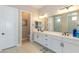 Bathroom with double sink vanity, white cabinets and a door to a private toilet at 10943 Doresta Ave, Las Vegas, NV 89166