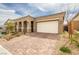 Attractive single-story home with a brick driveway, desert landscaping, and a two-car garage at 10943 Doresta Ave, Las Vegas, NV 89166