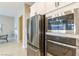 Stainless steel refrigerator and microwave in modern kitchen with view to dining room at 10943 Doresta Ave, Las Vegas, NV 89166