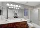 Bright bathroom features a double sink vanity, a large mirror and a shower-over-tub at 10965 Ladyburn Ct, Las Vegas, NV 89141