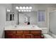 Bright bathroom features a double sink vanity, a large mirror and a shower-over-tub at 10965 Ladyburn Ct, Las Vegas, NV 89141