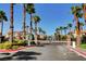 Community entrance with gated access, lush greenery, and multiple palm trees at 10965 Ladyburn Ct, Las Vegas, NV 89141